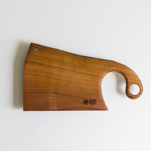 Ručno rađena drvena daska za rezanje od parenog oraha sa elegantno zakrivljenom ručkom i rupom za kačenje.
